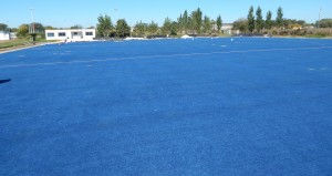 La cancha de hockey ya cuenta con su alfombra de cesped sintetico extendida en el terreno