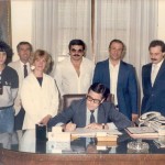 En 1986, durante la firma de la escritura correspondiente al terreno de la Sociedad de Fomento de Barrio Parque «Julio de Vedia». De izq. a der., Carlos De Sogos, Roberto Lafulla, escribano Jorge Cardinal, Zulma García, Jorge Giulietti, Héctor Pueblas y Omar Malondra; sentado, el Intendente Municipal Abel De la Plaza .